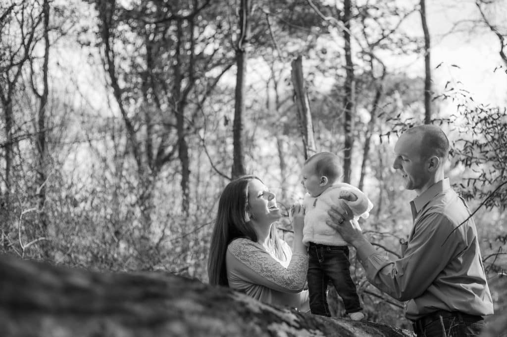 Parents and toddler in the woods.