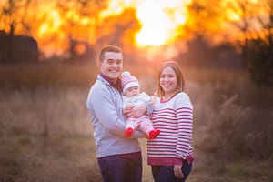Family with sunset behind.